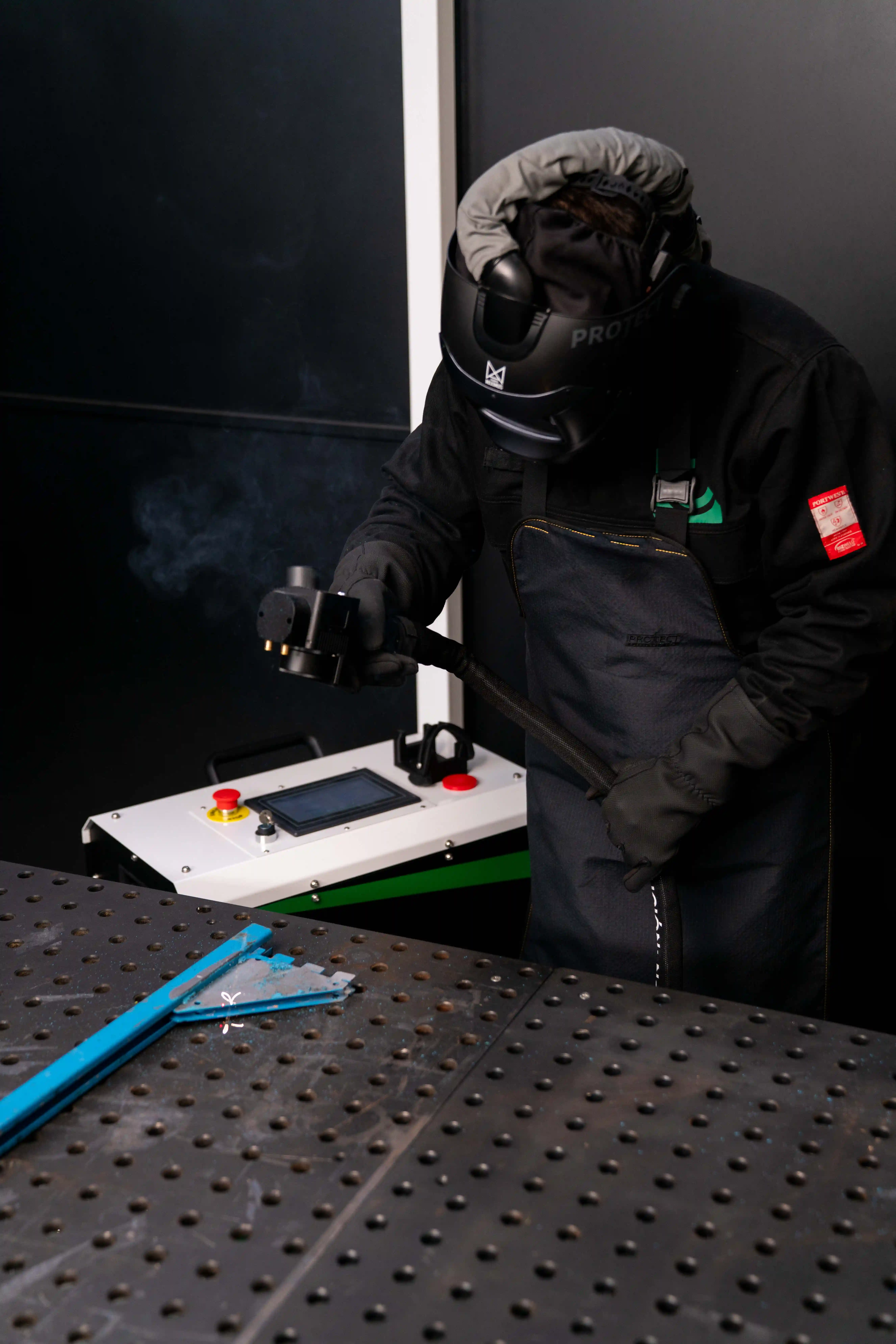 Operario certificado de LASERAND trabajando con equipo láser de alta potencia en planta del cliente